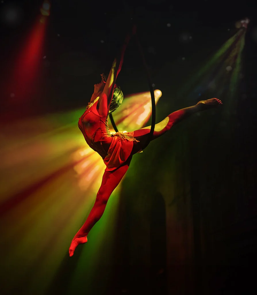 Luftakrobatik-Show im Kunz Theatre: Artistin Anastasiia Vaschenko vollführt eine elegante Pose im Luftring (Aerial Hoop) unter dramatischem Bühnenlicht.